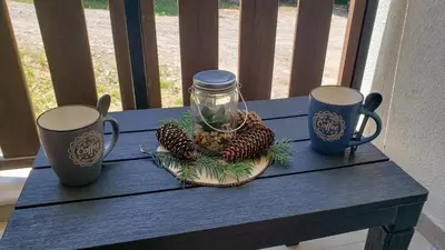 a table with two mugs and a jar of pine cones at KLEPALSKI - Mountain Studio in Borovets