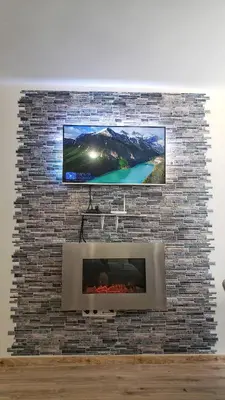 a tv on top of a brick wall with a fireplace at KLEPALSKI - Mountain Studio in Borovets