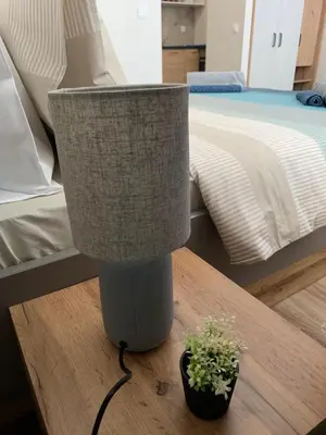 a lamp sitting on a table next to a bed at KLEPALSKI - Mountain Studio in Borovets