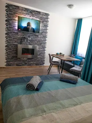 a bedroom with a tv on a brick wall at KLEPALSKI - Mountain Studio in Borovets