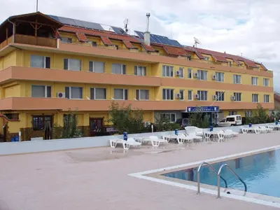 a hotel with tables and chairs in front of a building at Komitite Complex in Chuchuligovo