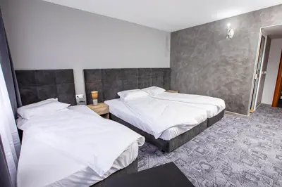 two beds in a hotel room with white sheets at Komitite Complex in Chuchuligovo