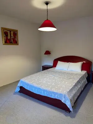 a bedroom with a large bed and a red lamp at Villa Alexa in Borovets