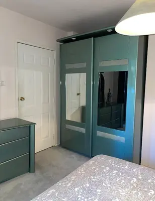 a bedroom with a blue cabinet and a mirror at Villa Alexa in Borovets