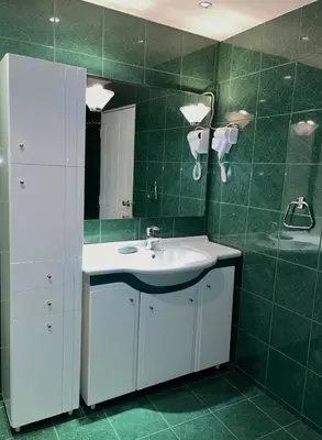 a bathroom with a white sink and green tiles at Villa Alexa in Borovets