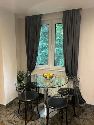 a dining room with a glass table and chairs and a window at Villa Alexa in Borovets