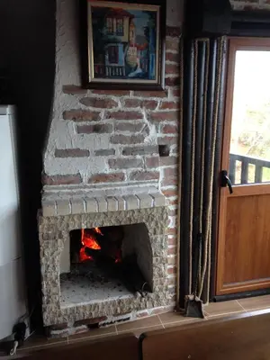 a brick fireplace with a fire in it at Александрова вила 2 in Zlatograd