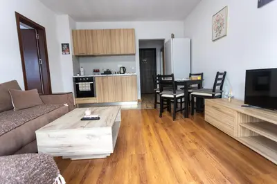 a living room with a couch and a table at Karastoyanovi's apartment- Studentski grad in Sofia