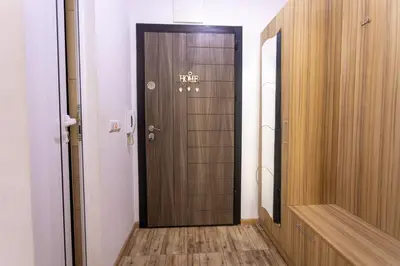 a hallway with a wooden door in a room at Karastoyanovi's apartment- Studentski grad in Sofia