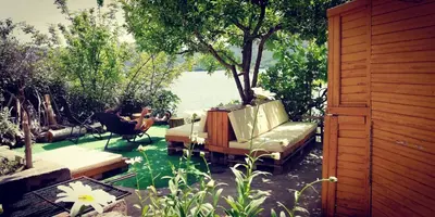a couch sitting on a patio next to the water at Lakeview Glamping in Staro Myasto