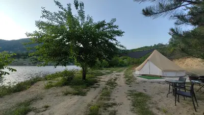 a tent and a table next to a lake at Lakeview Glamping in Staro Myasto