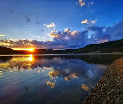 a view of a lake with the sun setting at Lakeview Glamping in Staro Myasto