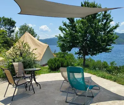 a patio with chairs and a table and a tent at Lakeview Glamping in Staro Myasto
