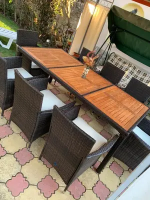 a wooden table and chairs on a patio at Sunny House in Madzhare