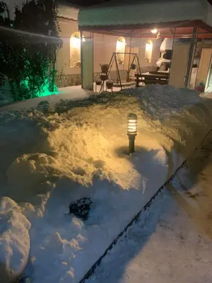 a light in the snow on a patio at night at Sunny House in Madzhare
