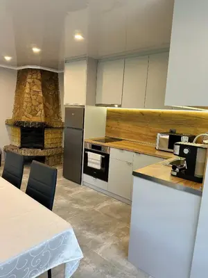 a kitchen with a stove and a stone fireplace at Sunny House in Madzhare