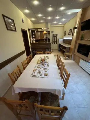a dining room with a long table and a piano at Advel Guest House in Madzhare