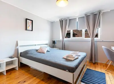 a bedroom with a bed and a chair and windows at Lovely 1-bedroom apartment in the center of Sofia in Sofia