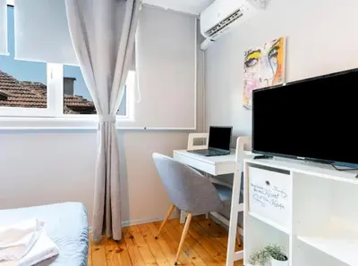 a room with a desk with a tv and a computer at Lovely 1-bedroom apartment in the center of Sofia in Sofia