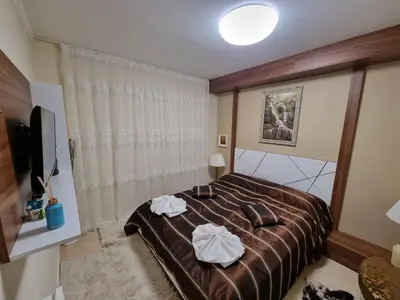 a bedroom with a bed with two towels on it at Гранд Манастира Лукс in Pamporovo