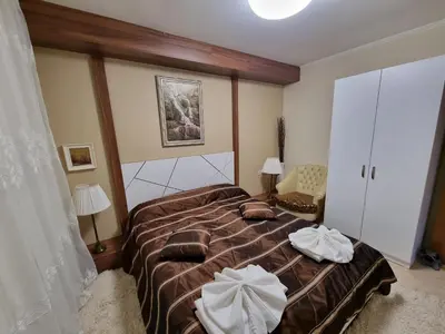 a bedroom with a large bed with two pillows on it at Гранд Манастира Лукс in Pamporovo
