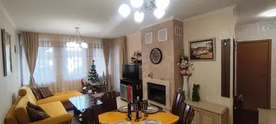 a living room with a couch and a christmas tree at Гранд Манастира Лукс in Pamporovo