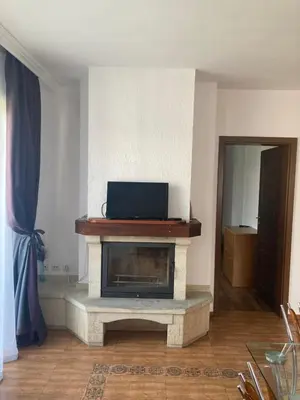 a living room with a fireplace with a television on top at GD Apartament in Bansko