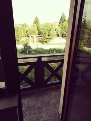 an open door to a balcony with a view of a park at GD Apartament in Bansko