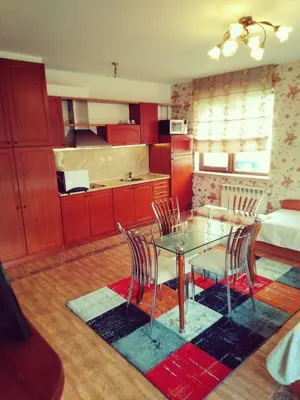 a kitchen and dining room with a glass table and chairs at GD Apartament in Bansko