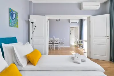 a bedroom with a white bed with yellow pillows at - The Blue Apartment - 1BD with Artistic Interior Design by Flat Mаnager in Sofia
