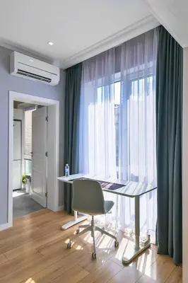 a desk and a chair in a room with windows at - The Blue Apartment - 1BD with Artistic Interior Design by Flat Mаnager in Sofia