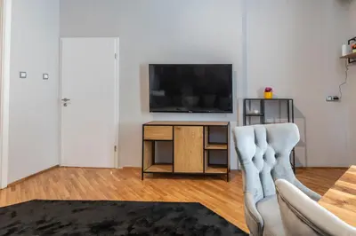 a living room with a television and a couch at Luxury Vitosha Apartment in Sofia