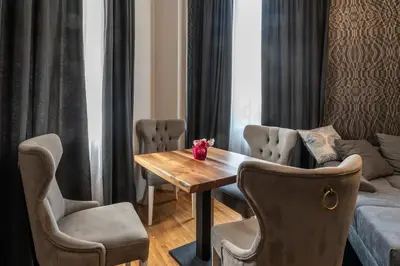 a dining room with a table and chairs and a couch at Luxury Vitosha Apartment in Sofia