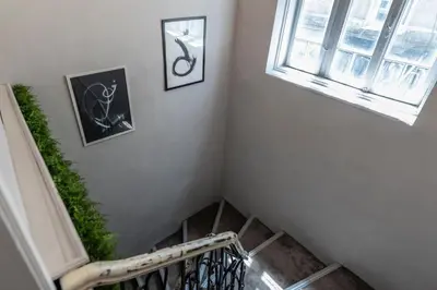 a staircase with two pictures on the wall and a window at Luxury Vitosha Apartment in Sofia