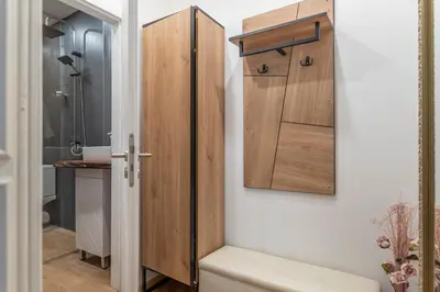 a bathroom with a wooden cabinet and a toilet at Luxury Vitosha Apartment in Sofia