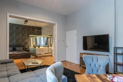 a living room with a couch and a television at Luxury Vitosha Apartment in Sofia