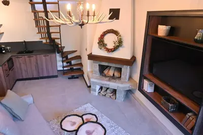 a living room with a fireplace and a chandelier at Marand Villas in Bansko