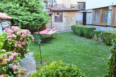 a yard with a chair and flowers and a house at Marand Villas in Bansko