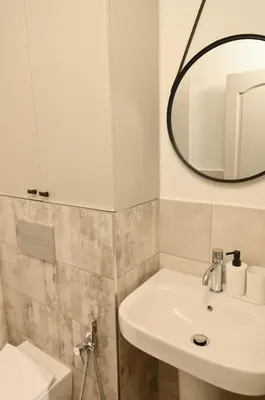 a bathroom with a sink and a mirror and a toilet at Marand Villas in Bansko
