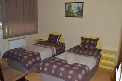 a hotel room with three beds in a room at Dionis Hotel in Petrich