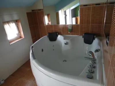 a white bath tub in a bathroom with a mirror at Dionis Hotel in Petrich