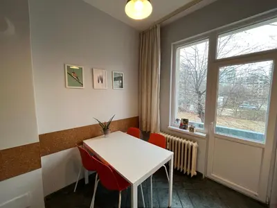 a dining room with a white table and red chairs at 113 in Sofia with 2BR and 2 full bath in Sofia