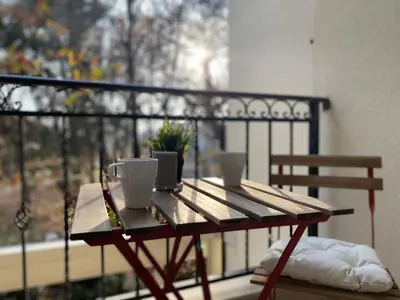 a wooden table with two cups on a balcony at Green park Sandanski in Sandanski