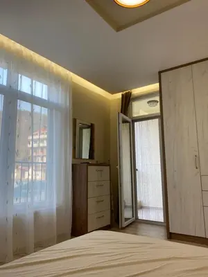 a bedroom with a bed and a dresser and a window at Green park Sandanski in Sandanski