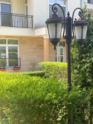 a street light in front of a house with bushes at Green park Sandanski in Sandanski