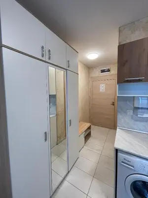 a kitchen with white cabinets and a washing machine at Colonel apartment 938 in Sofia