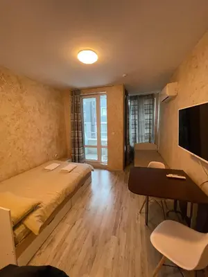 a bedroom with a bed and a desk and a tv at Colonel apartment 938 in Sofia