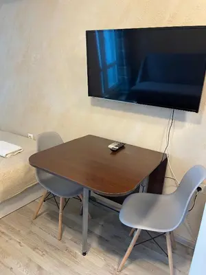 a table and chairs with a television on a wall at Colonel apartment 945 in Sofia