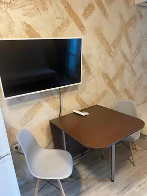 a table with two chairs and a television on a wall at Colonel apartment 946 in Sofia