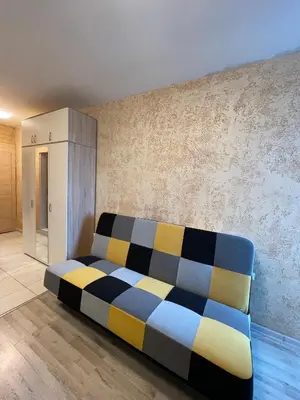 a bed in a room next to a wall at Colonel apartment 947 in Sofia